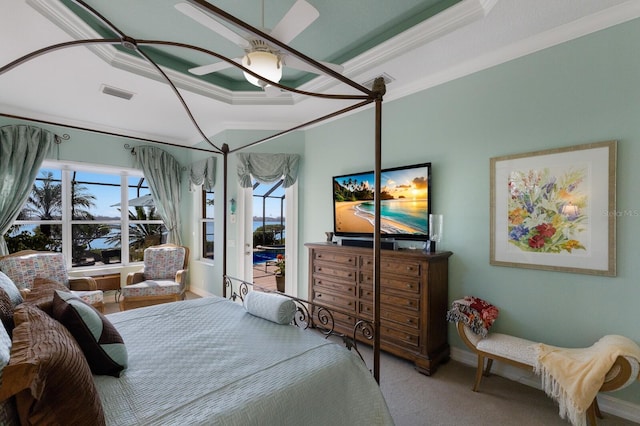 carpeted bedroom with ceiling fan, crown molding, and a tray ceiling