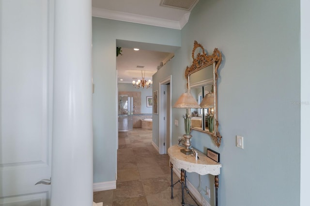 corridor with crown molding and an inviting chandelier