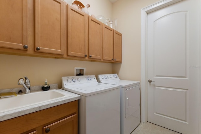 laundry room with cabinets, independent washer and dryer, and sink