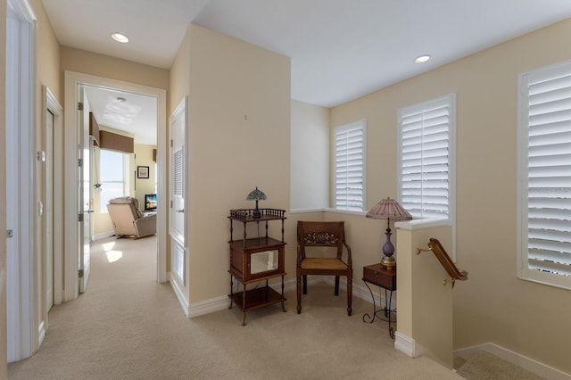 hallway featuring light carpet and a wealth of natural light