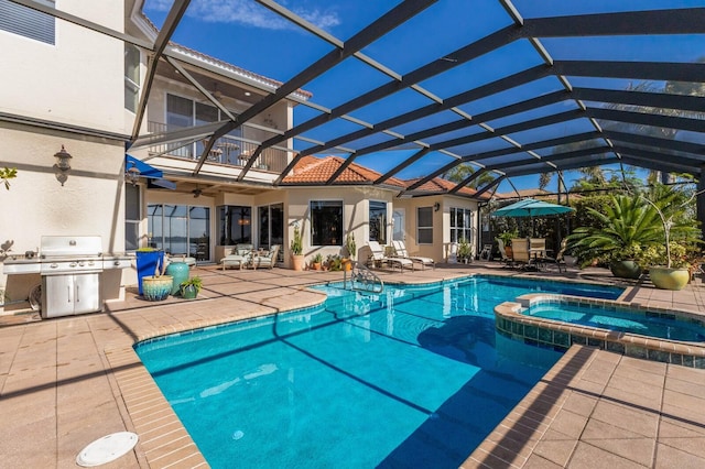 view of swimming pool featuring an in ground hot tub, area for grilling, glass enclosure, and a patio area