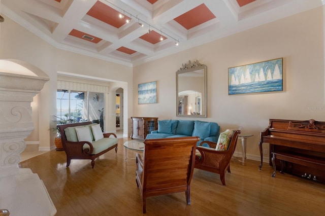 living area with visible vents, arched walkways, beamed ceiling, and wood finished floors
