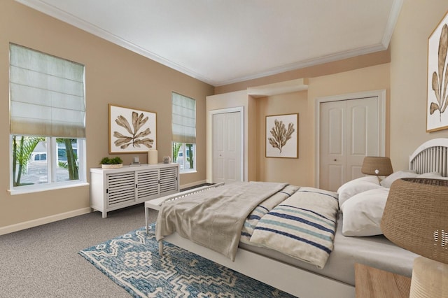 bedroom with carpet flooring, crown molding, baseboards, and multiple closets