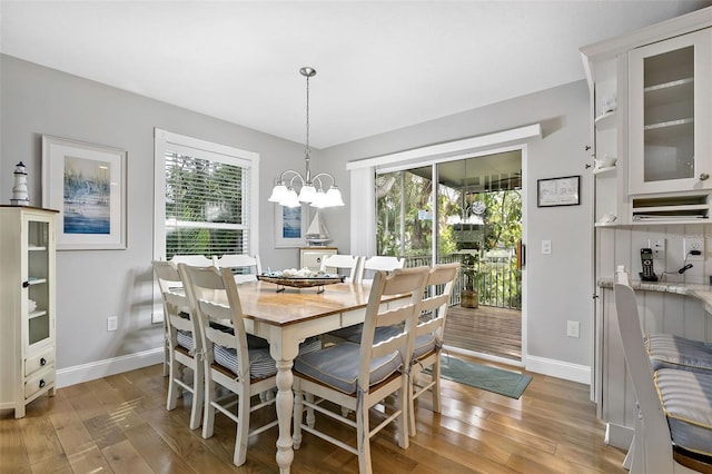 dining room featuring a wealth of natural light, light hardwood / wood-style floors, and an inviting chandelier