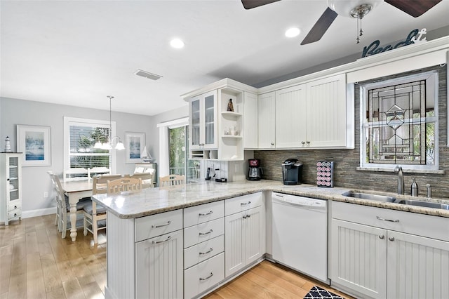 kitchen with kitchen peninsula, white cabinets, sink, pendant lighting, and dishwasher