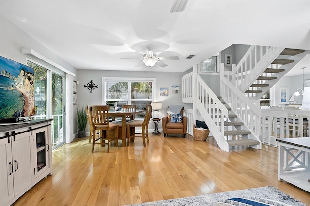 dining room featuring ceiling fan, light hardwood / wood-style flooring, and a healthy amount of sunlight