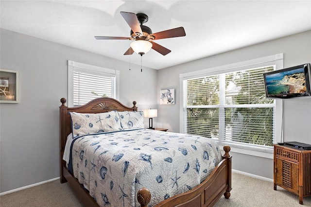 carpeted bedroom featuring multiple windows and ceiling fan