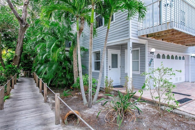 view of property exterior with a garage and a balcony