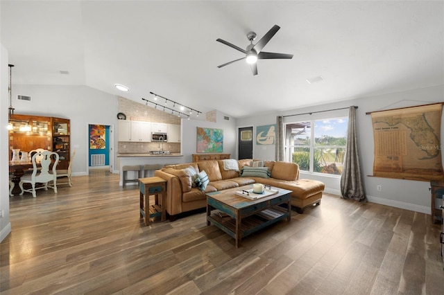 living room with dark hardwood / wood-style flooring, track lighting, vaulted ceiling, and ceiling fan