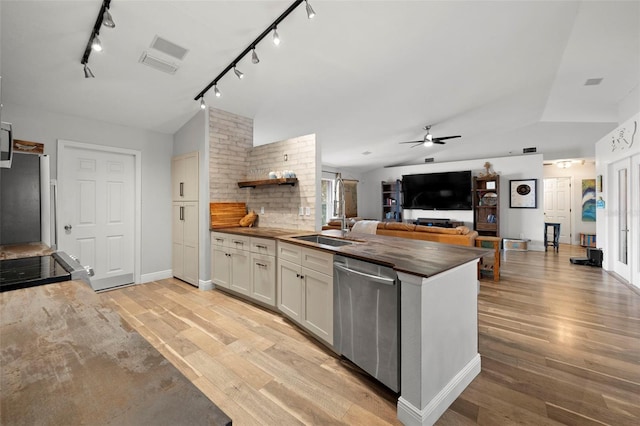 kitchen with butcher block counters, white cabinetry, light hardwood / wood-style floors, and appliances with stainless steel finishes