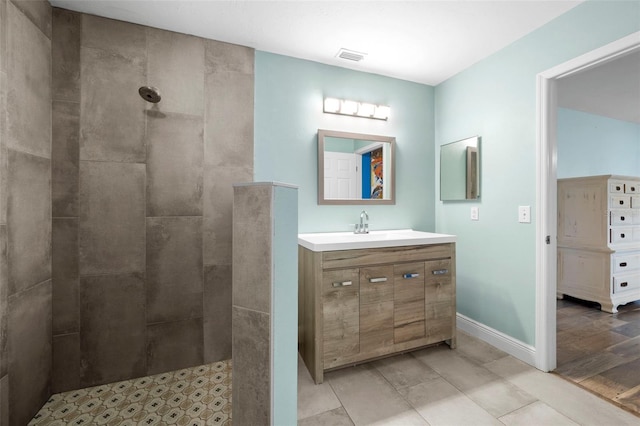 bathroom featuring tiled shower, vanity, and hardwood / wood-style flooring