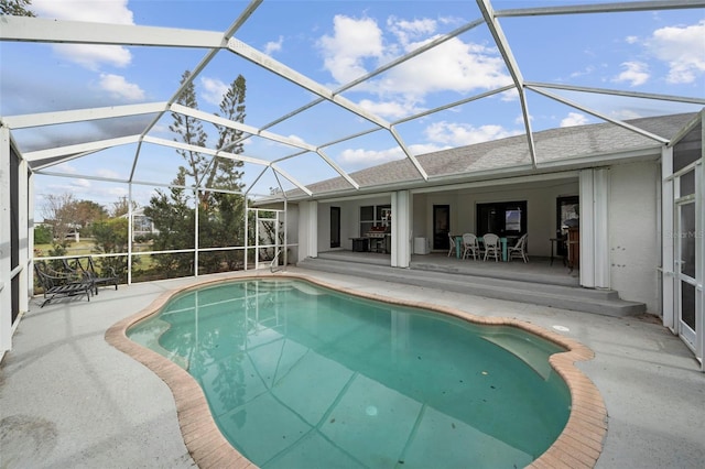 view of pool featuring glass enclosure and a patio