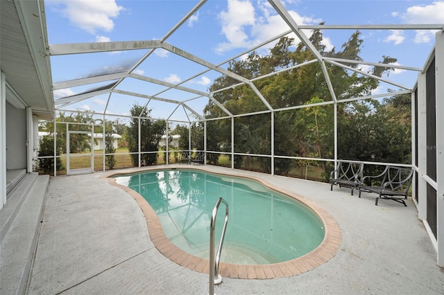 view of pool featuring glass enclosure and a patio area