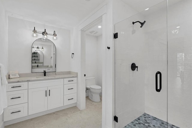 bathroom featuring a shower with door, vanity, and toilet