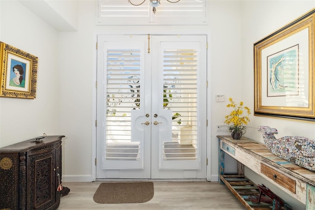 doorway to outside featuring french doors, baseboards, and light wood-style floors