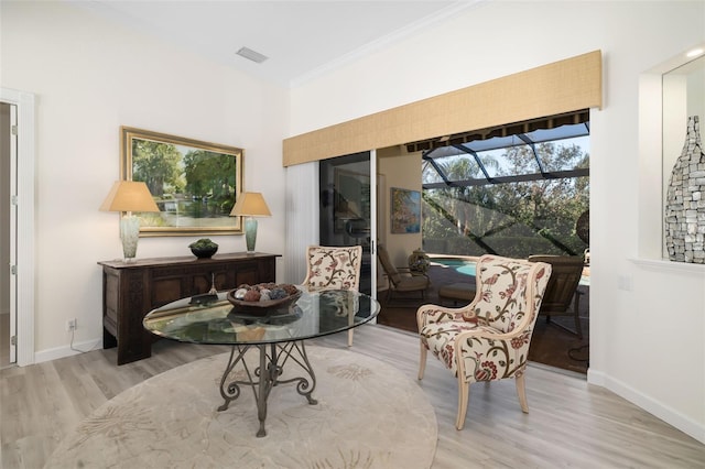 sitting room featuring crown molding and light wood-type flooring