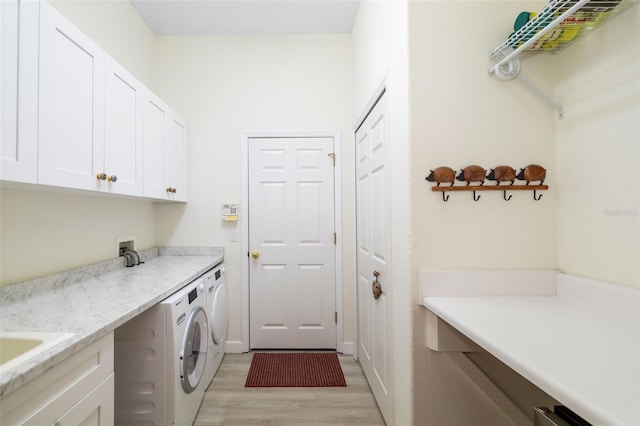 clothes washing area with light hardwood / wood-style flooring, cabinets, and independent washer and dryer