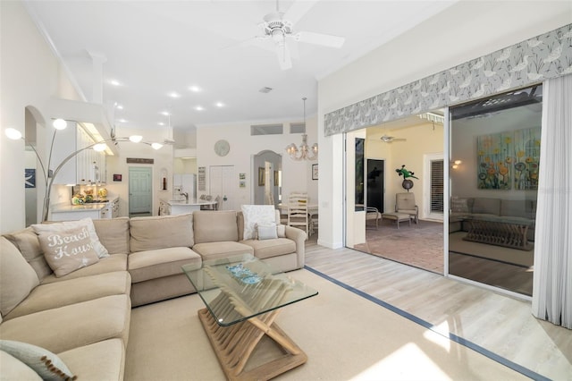 living room with ceiling fan, light wood-type flooring, and ornamental molding