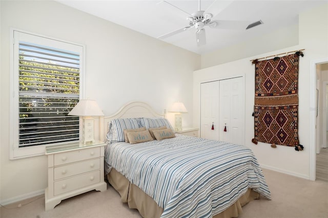 carpeted bedroom with ceiling fan and a closet