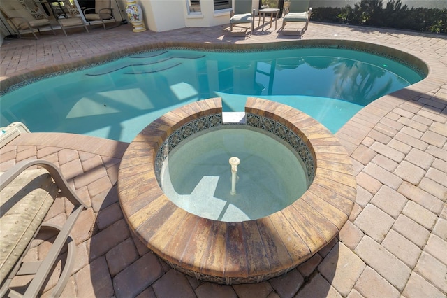 view of swimming pool featuring an in ground hot tub and a patio