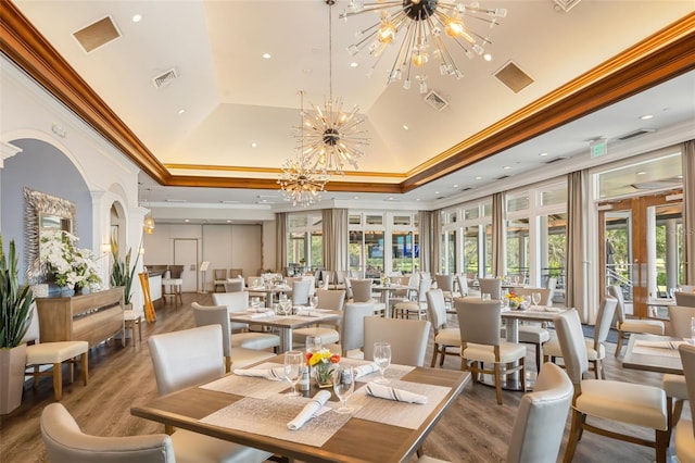 dining area featuring a raised ceiling, french doors, ornamental molding, and a notable chandelier