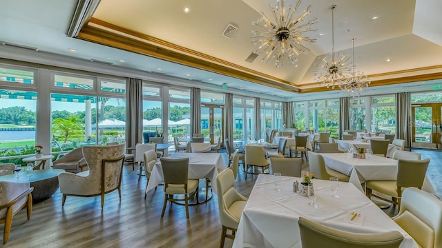 dining room with visible vents, crown molding, a chandelier, wood finished floors, and a raised ceiling