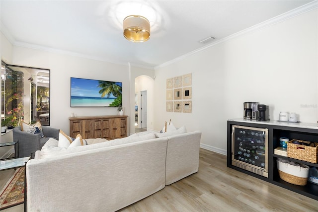 living room featuring light wood-type flooring, beverage cooler, and ornamental molding