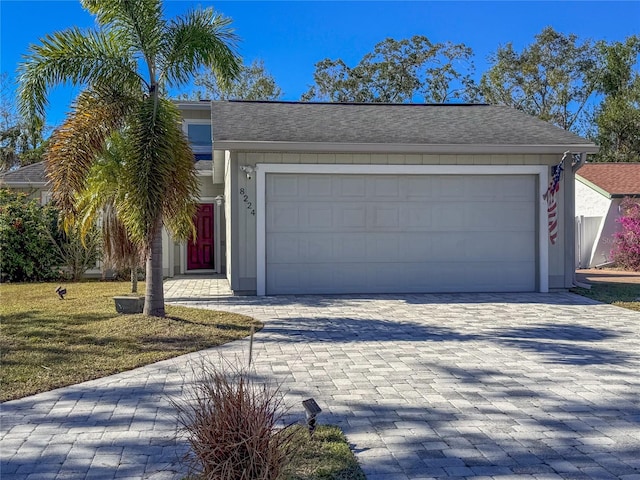 single story home featuring a front yard and a garage