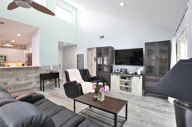 living room featuring ceiling fan and high vaulted ceiling