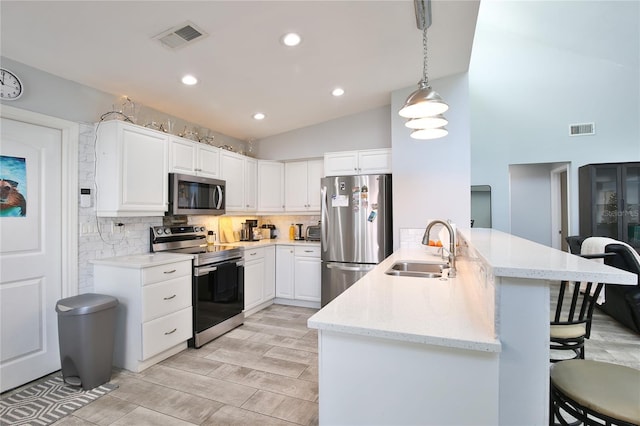 kitchen featuring white cabinets, pendant lighting, sink, and appliances with stainless steel finishes