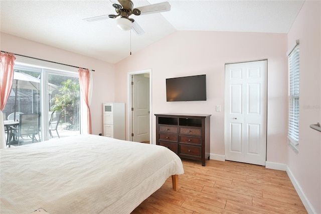 bedroom with access to exterior, ceiling fan, light hardwood / wood-style flooring, vaulted ceiling, and a closet