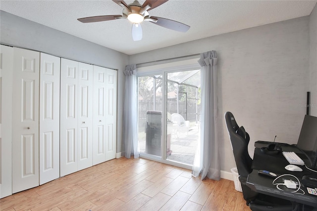 office area featuring a textured ceiling, light hardwood / wood-style flooring, and ceiling fan