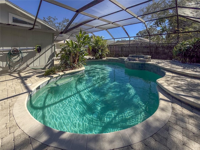 view of pool with glass enclosure, an in ground hot tub, and a patio area