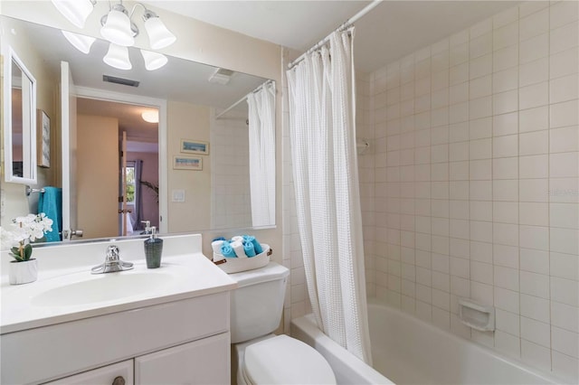 full bathroom featuring vanity, shower / bathtub combination with curtain, a notable chandelier, and toilet