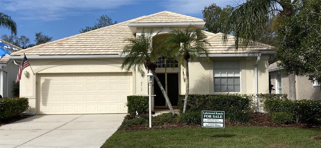 single story home featuring a garage, a tile roof, driveway, and stucco siding