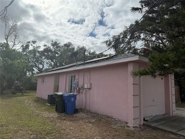 view of home's exterior with central AC and a garage