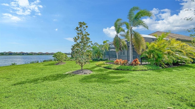 view of yard featuring glass enclosure and a water view