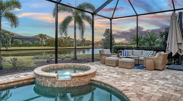 pool at dusk featuring an in ground hot tub and a water view