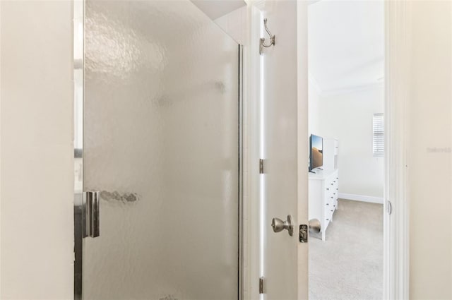 bathroom with crown molding and walk in shower