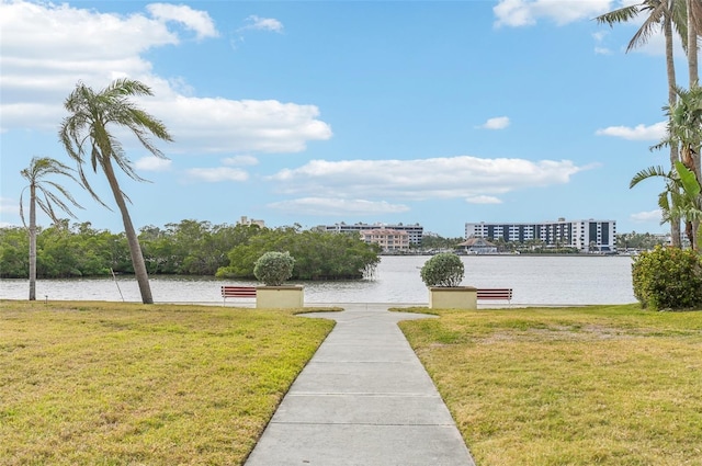 view of property's community featuring a lawn and a water view