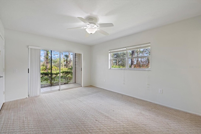 carpeted empty room featuring a ceiling fan and baseboards