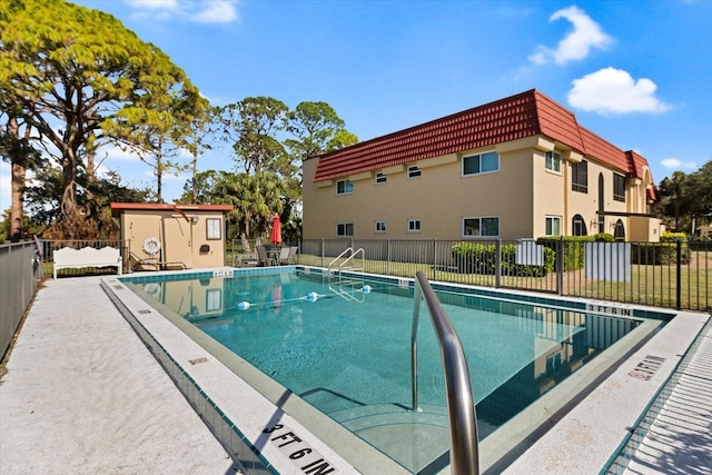 community pool featuring fence and a patio