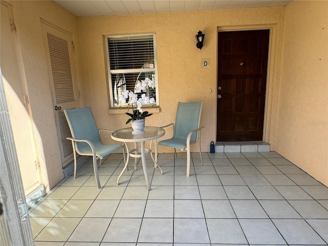 view of exterior entry featuring a patio area and stucco siding