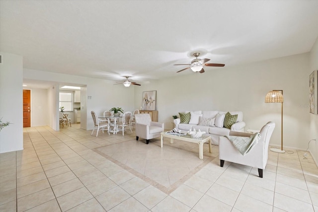 living room with ceiling fan, light tile patterned flooring, washer / dryer, and baseboards