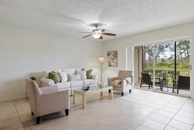 living room featuring light tile patterned floors, ceiling fan, and a textured ceiling