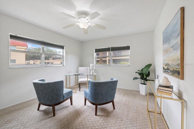 living area featuring a ceiling fan, carpet, and baseboards