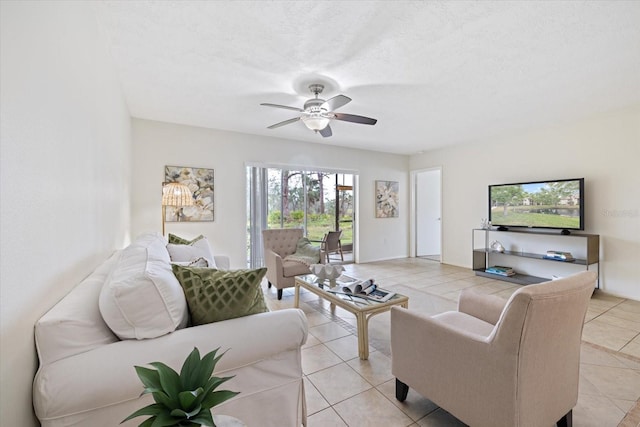 living room with light tile patterned floors, ceiling fan, and a textured ceiling