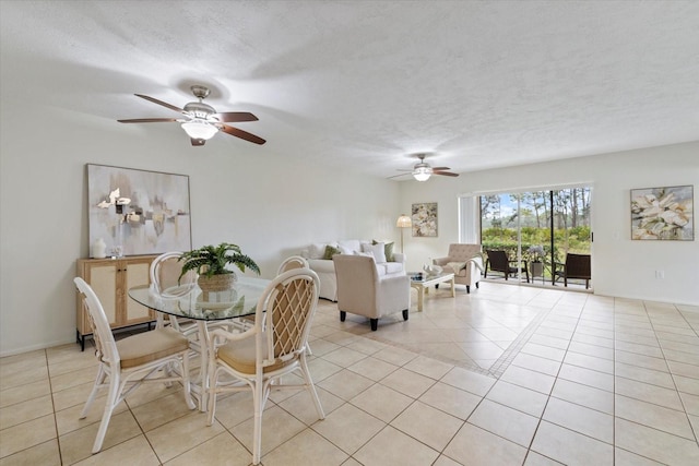 dining area featuring light tile patterned floors, ceiling fan, and a textured ceiling