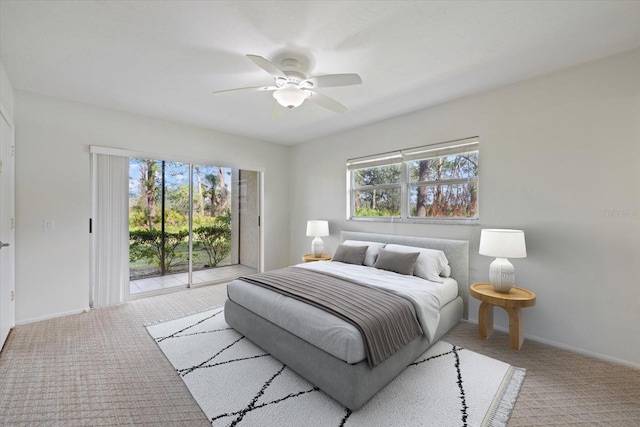 carpeted bedroom featuring access to outside, a ceiling fan, and baseboards