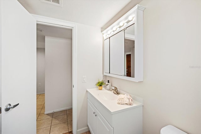 bathroom featuring visible vents, baseboards, toilet, tile patterned flooring, and vanity